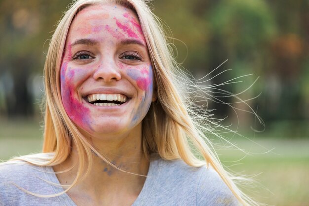 Mulher sorridente feliz mostra seu rosto colorido