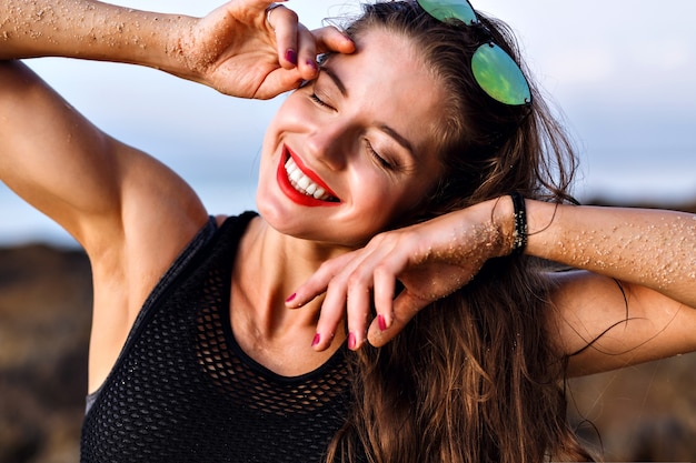 Mulher sorridente feliz positiva se divertindo e aproveitando o verão, close-up retrato, pele perfeita e maquiagem natural, conceito relaxante.