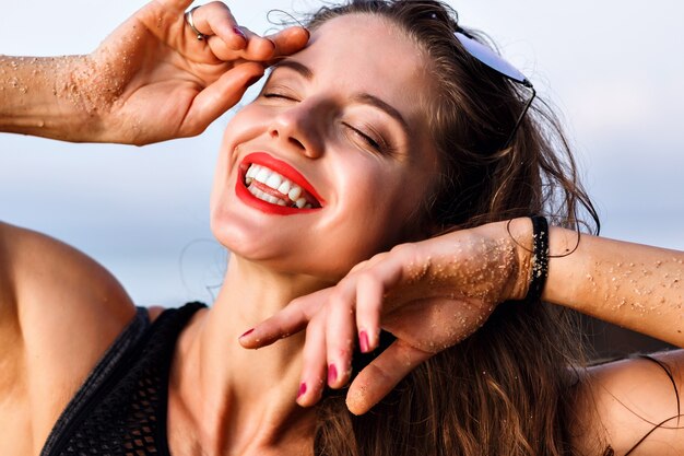 Mulher sorridente feliz positiva se divertindo e aproveitando o verão, close-up retrato, pele perfeita e maquiagem natural, conceito relaxante.