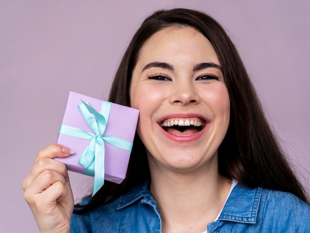 Mulher sorridente feliz segurando uma caixa de presente