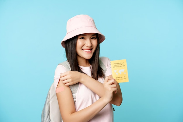 Mulher sorridente feliz turista coreana mostra seu braço, braço vacinado e vacinação internacional cobiçada ...