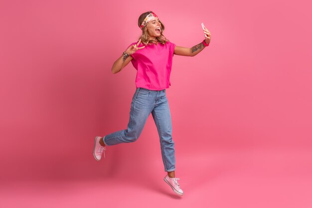 Mulher sorridente muito fofa em uma camisa rosa boho hippie acessórios sorrindo diversão emocional posando em rosa