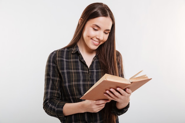 Mulher sorridente na camisa lendo livro