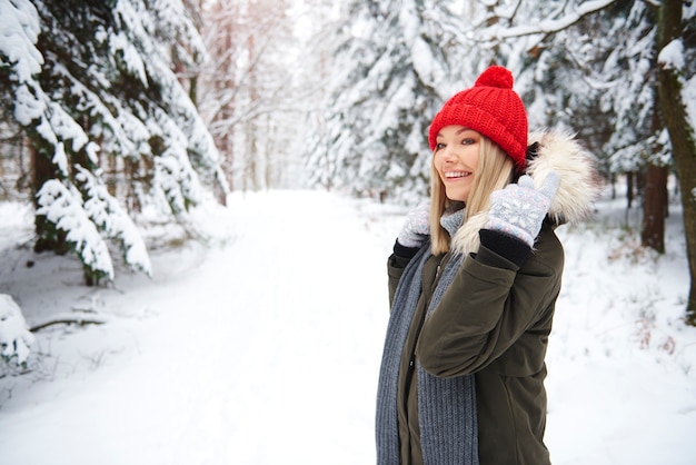 Mulher sorridente na floresta de inverno