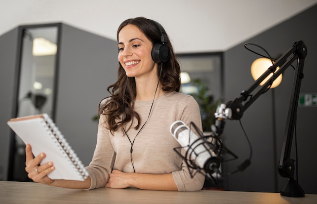 Foto grátis mulher sorridente no estúdio durante um programa de rádio