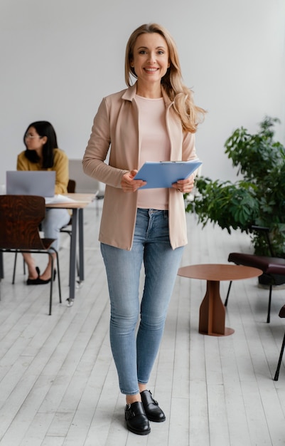 Foto grátis mulher sorridente posando ao lado de seus colegas de trabalho