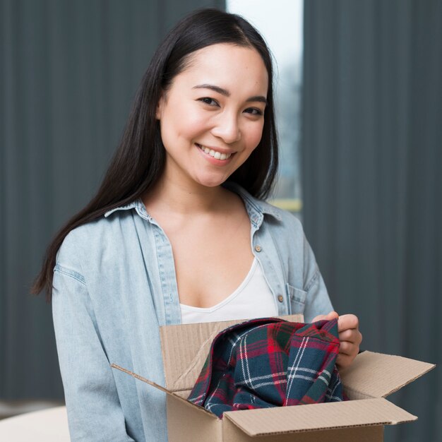 Mulher sorridente posando com caixa que ela pediu on-line