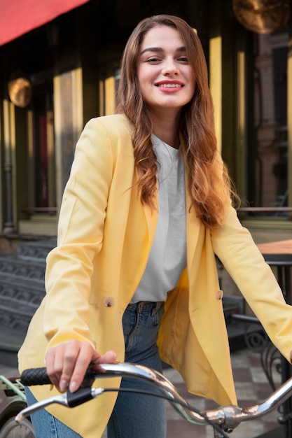 Mulher sorridente posando enquanto andava de bicicleta na rua da cidade