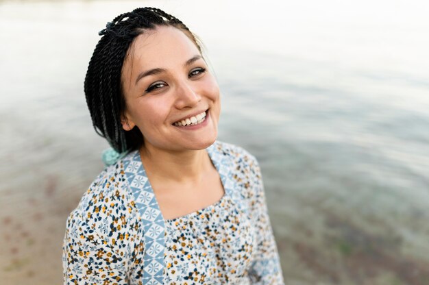 Mulher sorridente posando na beira-mar