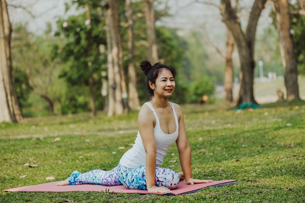 Foto grátis mulher sorridente que faz ioga na natureza