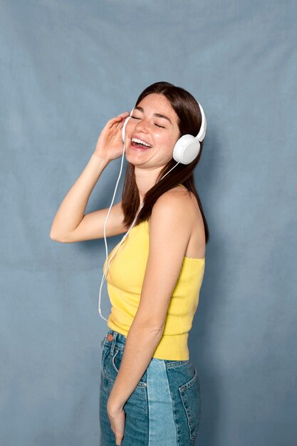 Mulher sorridente se divertindo com fones de ouvido