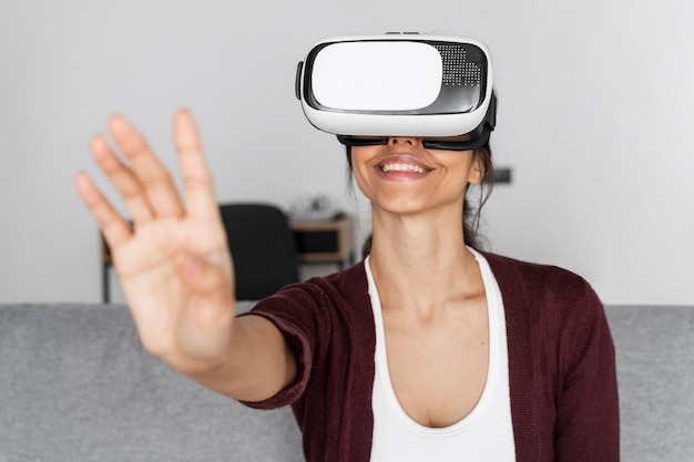 Foto grátis mulher sorridente se divertindo em casa com fone de ouvido de realidade virtual