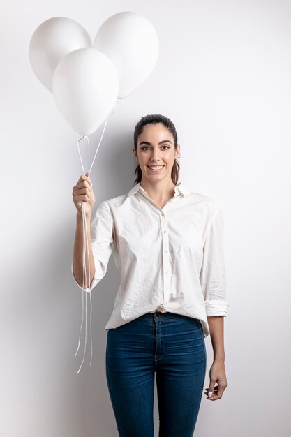 Foto grátis mulher sorridente segurando balões