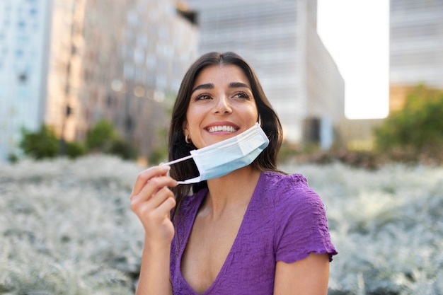 Mulher sorridente segurando máscara de tiro médio