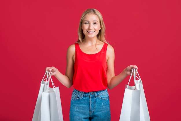 Foto grátis mulher sorridente segurando muitas sacolas de compras