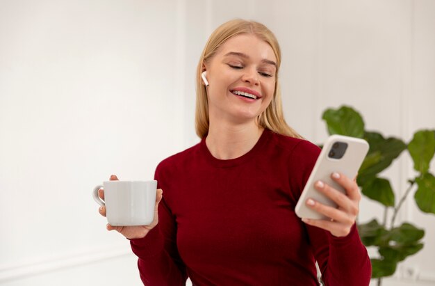 Mulher sorridente segurando smartphone com foto média