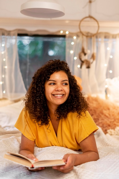 Foto grátis mulher sorridente segurando um livro