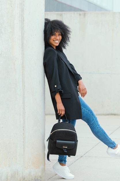 Mulher sorridente segurando uma mochila