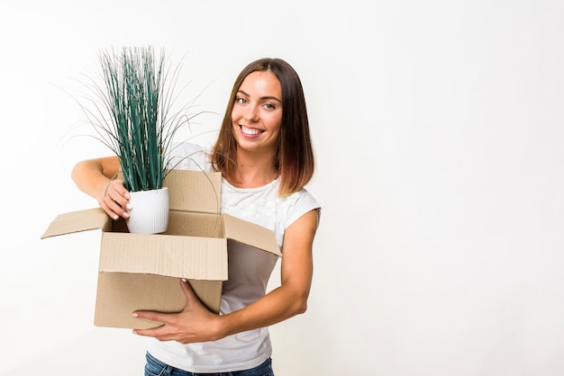 Mulher sorridente segurando uma planta