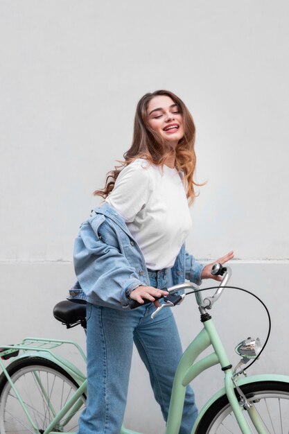 Mulher sorridente sentada em sua bicicleta