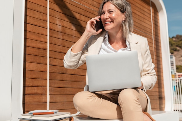 Mulher sorridente trabalhando em um laptop