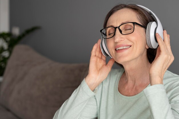 Mulher sorridente usando fones de ouvido de perto