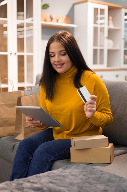 Mulher sorridente verificando o tablet para uma nova compra na cibernética segunda-feira