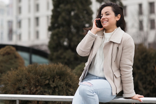 Mulher sorrindo e falando ao telefone