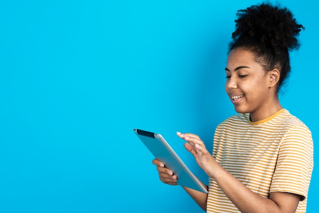 Mulher sorrindo e olhando para tablet