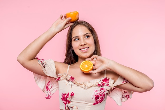 Mulher, sorrindo, e, tendo divertimento, com, cortado, laranja