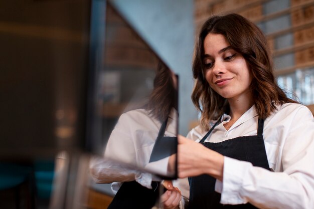 Mulher sorrindo e trabalhando na máquina de café