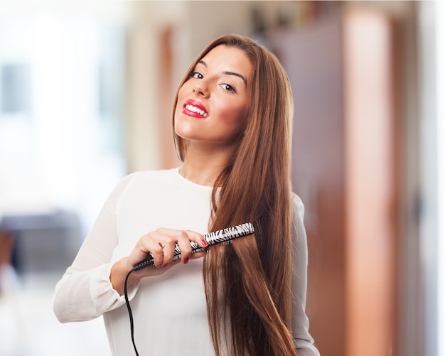 Foto grátis mulher, sorrindo, enquanto alisando o cabelo