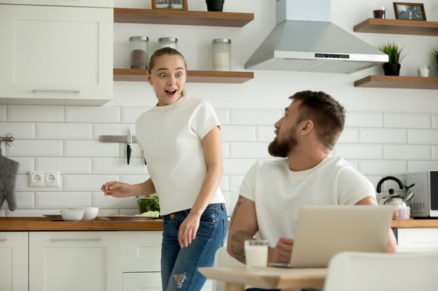 Mulher surpreendida animado para ouvir notícias do marido na cozinha