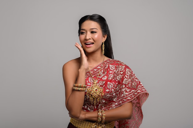 Mulher tailandesa bonita que veste um vestido tailandês e um sorriso feliz.