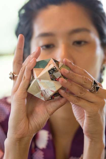 Mulher talentosa fazendo origami com papel japonês