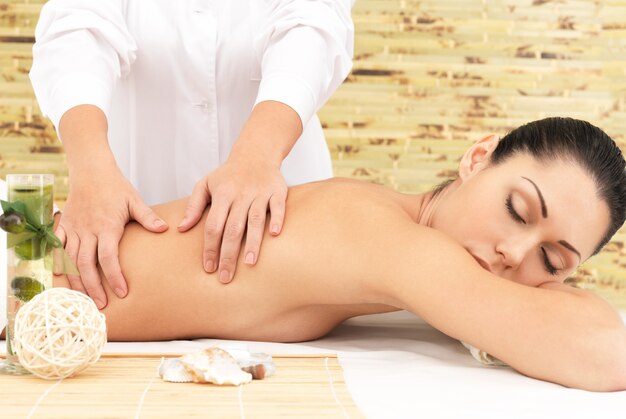 Mulher tendo massagem terapêutica de costas no salão spa. Conceito de tratamento de beleza.