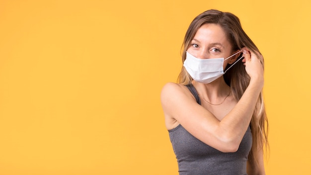 Mulher tirando a máscara facial com espaço de cópia