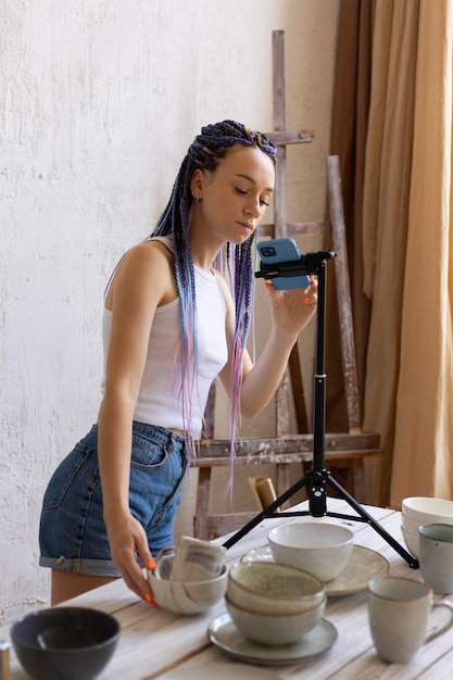 Foto grátis mulher tirando fotos para seu negócio com utensílios de cozinha