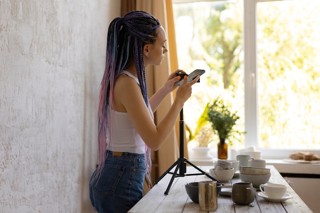 Mulher tirando fotos para sua empresa com utensílios de cozinha de cerâmica