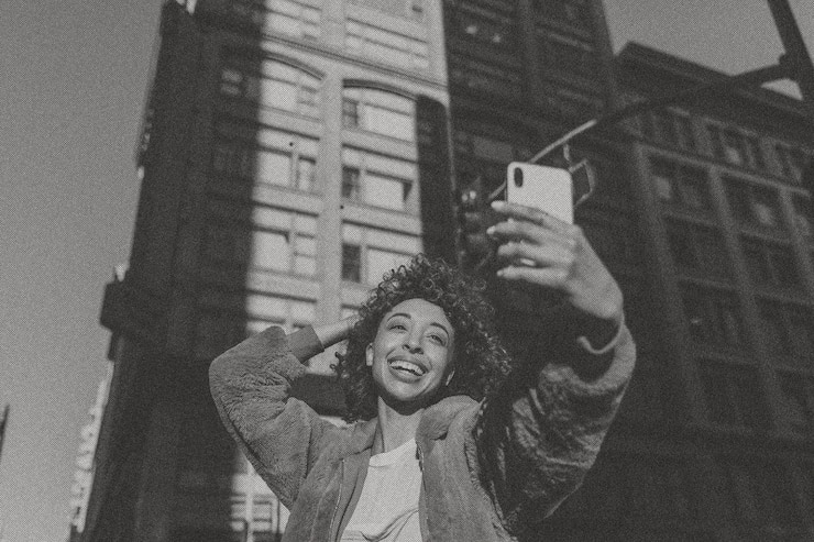 Foto grátis mulher tirando selfie na cidade em tons de preto e branco
