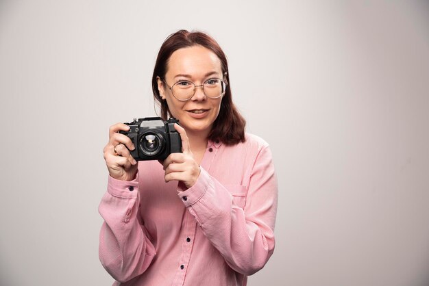 Mulher tirando uma foto com a câmera em branco. Foto de alta qualidade