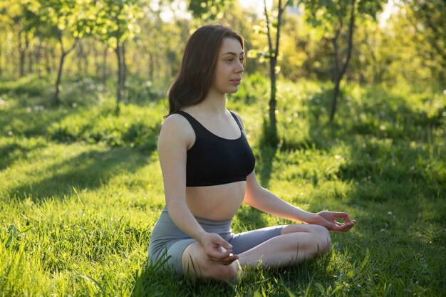 Mulher tiro cheio, meditando, ao ar livre