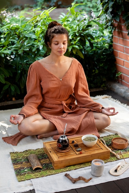 Mulher tiro cheio, meditando, ao ar livre