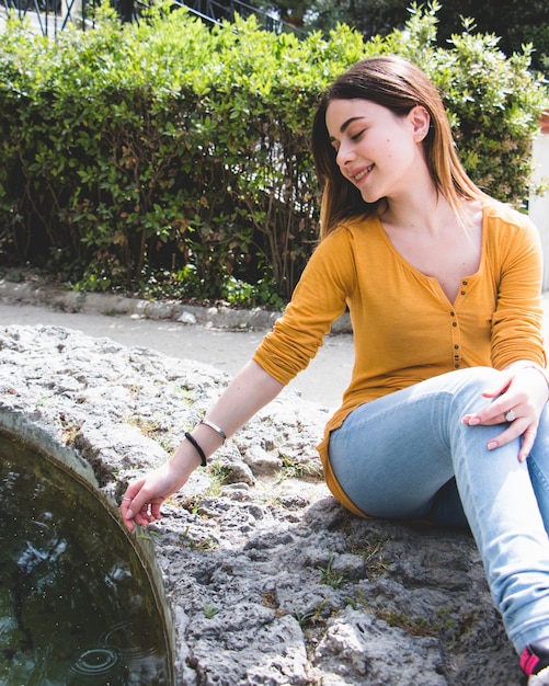 Foto grátis mulher tocando água na lagoa