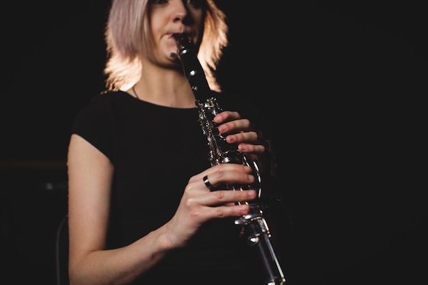 Mulher tocando clarinete na escola de música