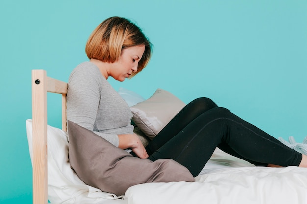 Foto grátis mulher, tocando, machucar, barriga, cama