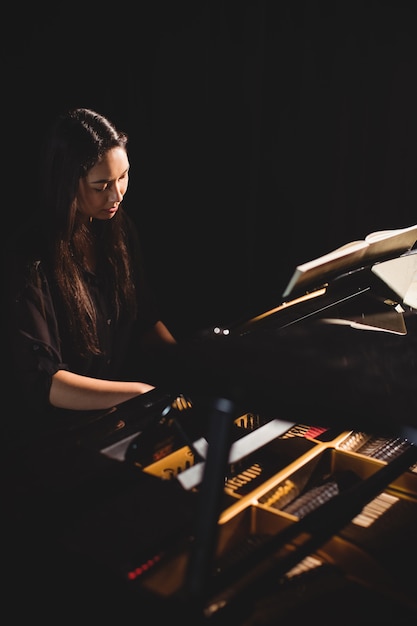 Mulher tocando piano no estúdio de música