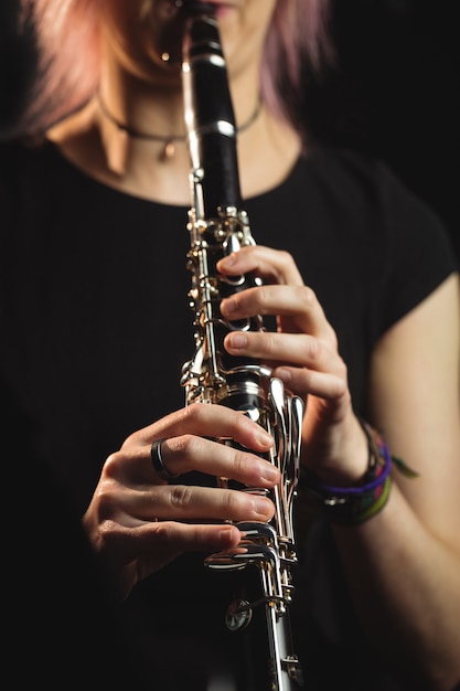 Mulher tocando um clarinete na escola de música