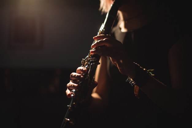 Mulher tocando um clarinete na escola de música