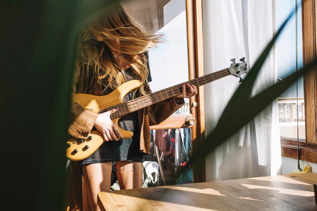 Mulher tocando violão na sala luz